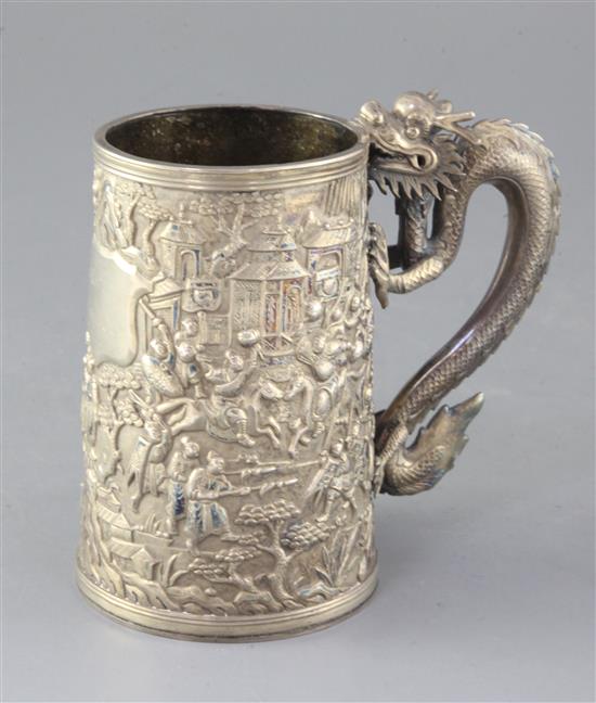 A mid-19th century Chinese silver mug, the body featuring warriors fighting to one side, with inscribed shield plaque H.13cm.